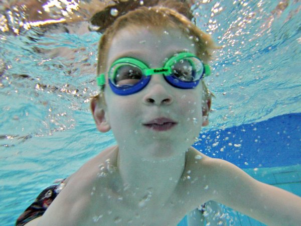 Junge unter Wasser mit Chlorbrille