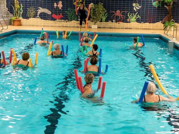 Personen im Schwimmbad mit Poolnudeln