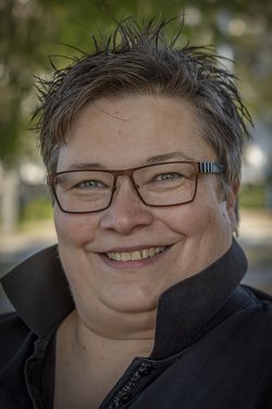 Frau mit kurzen strubbeligen Haaren und Brille