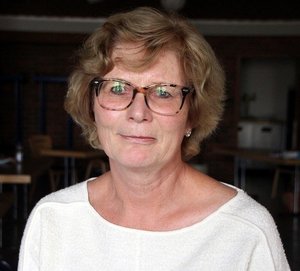 Blonde Frau mit Brille und einem weißen Pullover