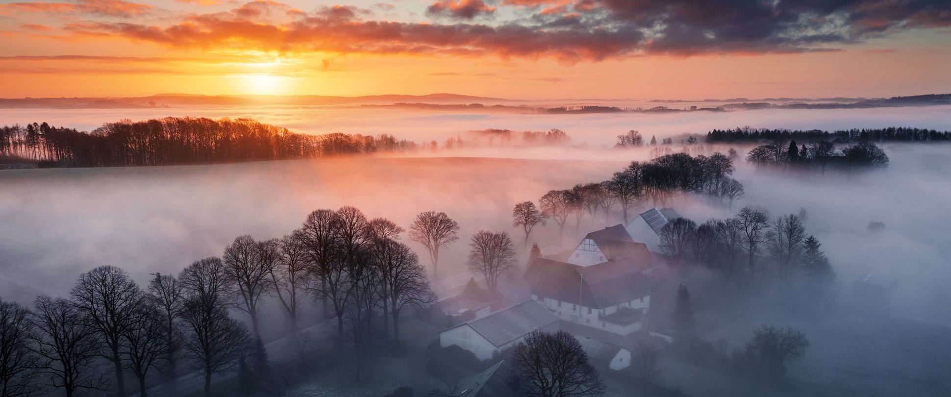 Ortschaft Burg bei Sonnenaufgang mit Morgennebel