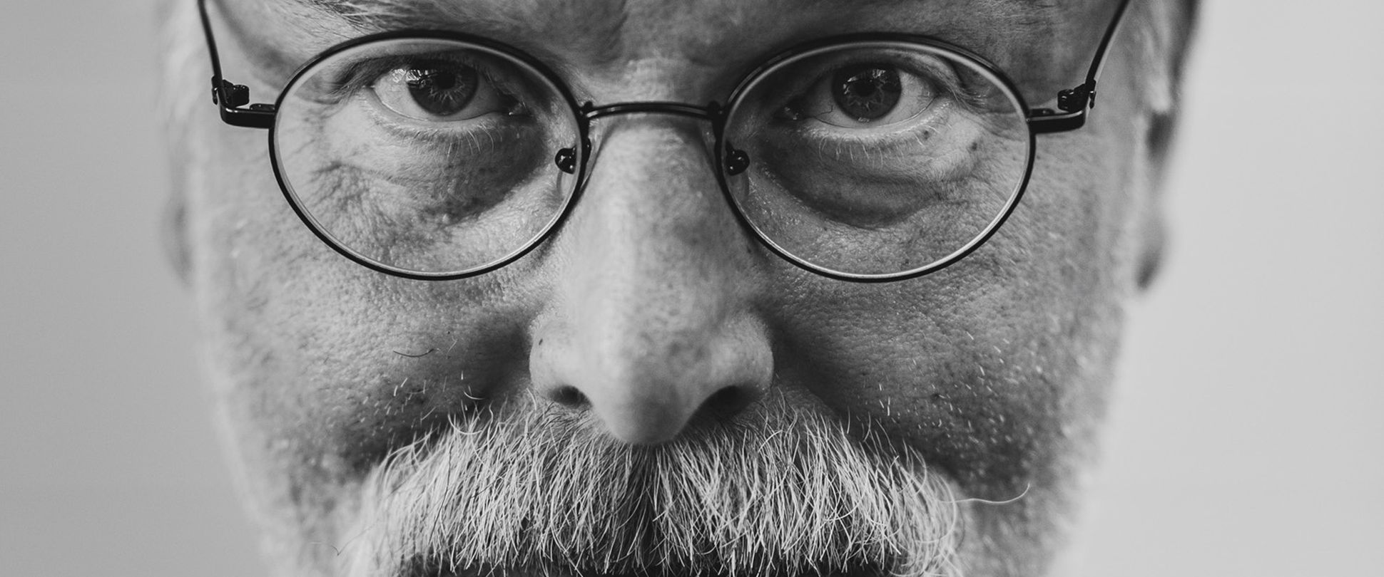 Mann mit grauem Bart und Brille